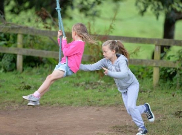 Children enjoying the swings at Heligan Campsite